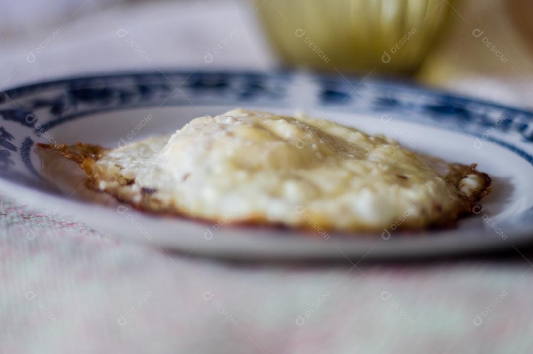 Ovo frito em um prato que está em uma mesa Imagem JPG