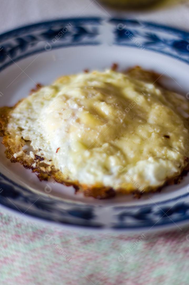 Ovo frito em um prato que está em uma mesa Imagem JPG