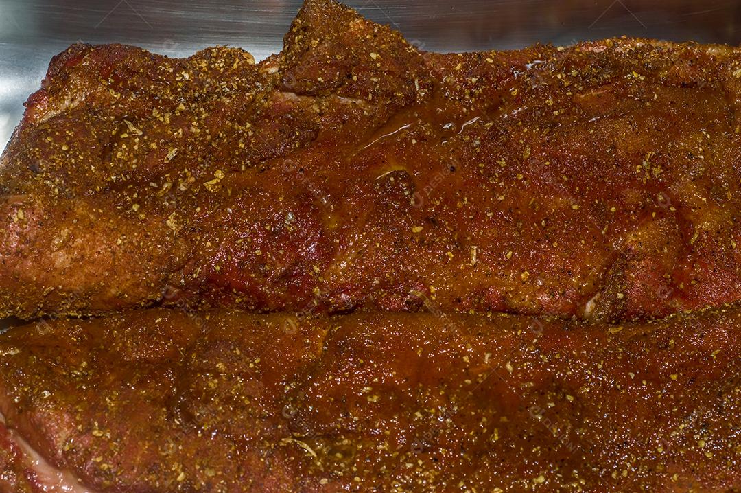 Costela bovina defumada fundo escuro homem segurando costela churrasco americano