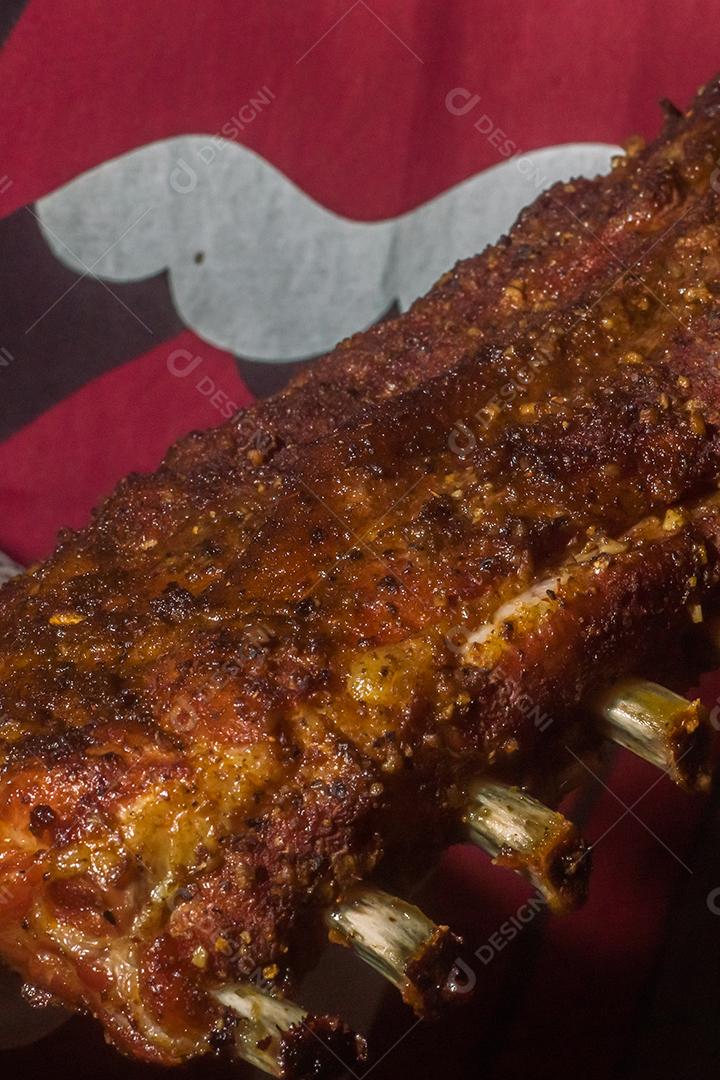 Smoked beef ribs with dark background man holding ribs, barbecue