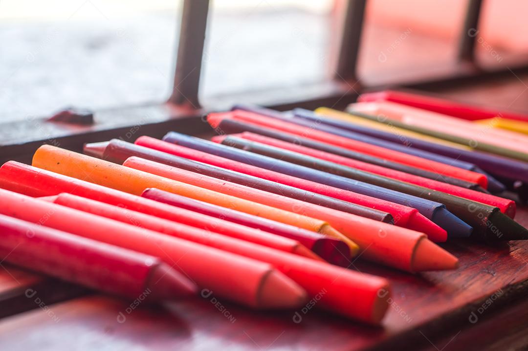 Giz de cera colorido, várias cores de giz de cera em uma mesa de madeira