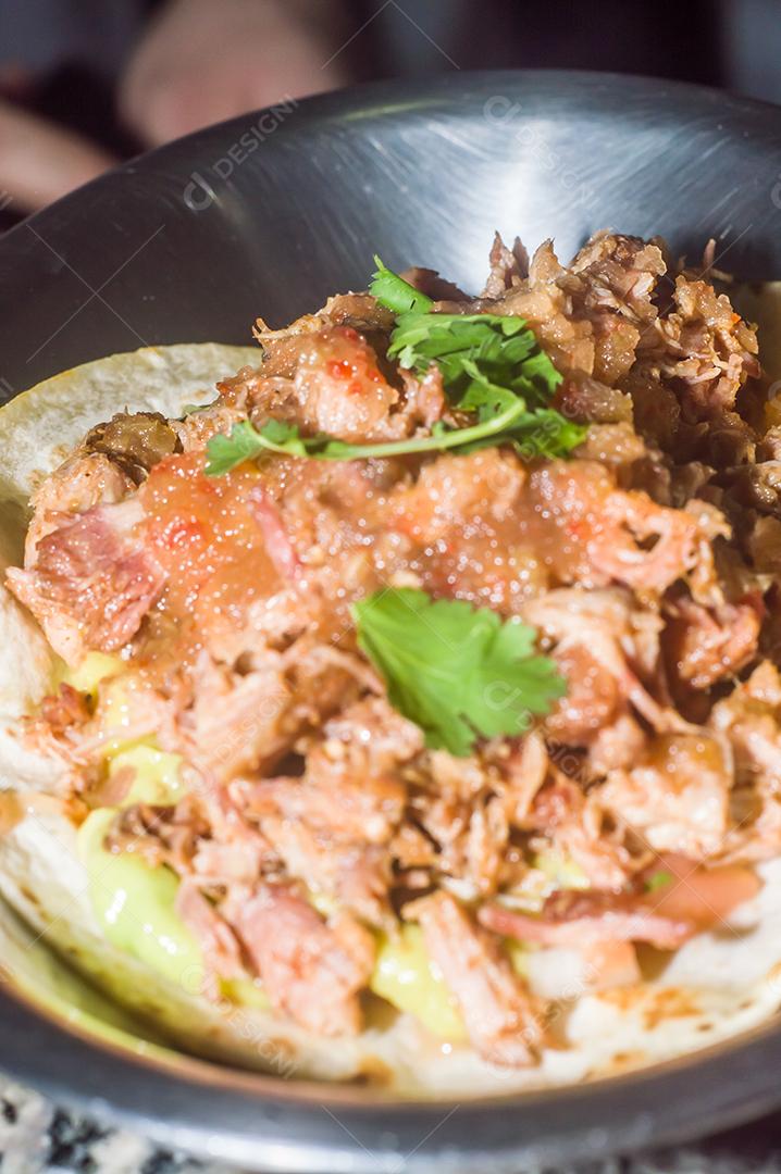 Espetinho de porco desfiado com tortilha, guacamole e fundo de maemore