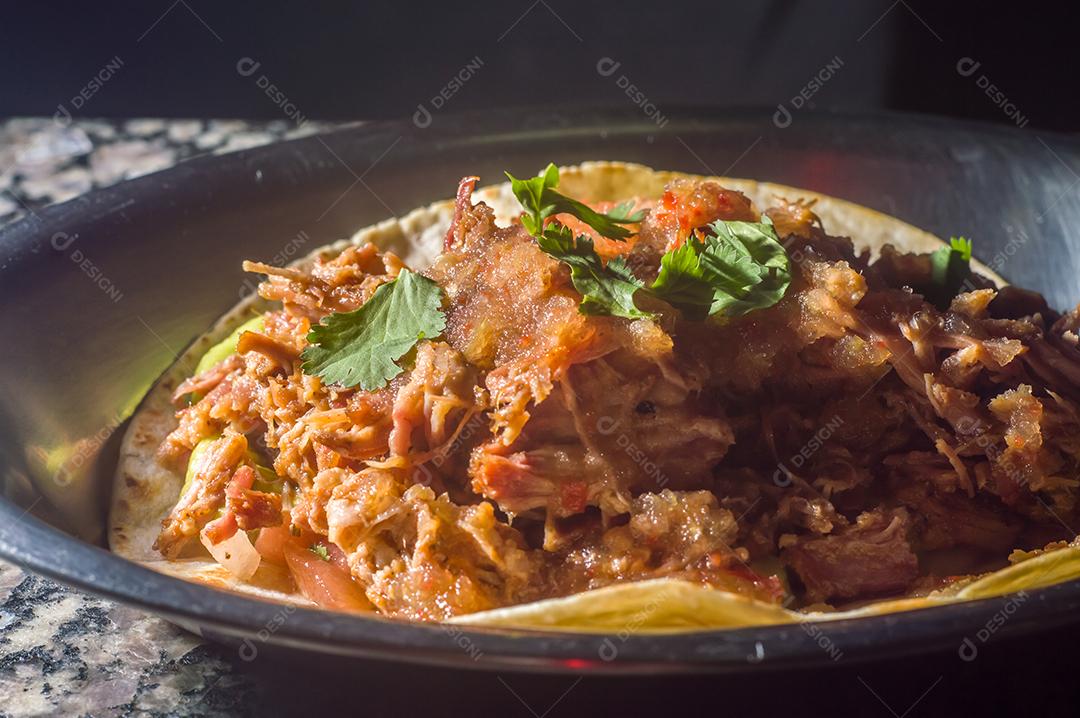 Espetinho de porco desfiado com tortilha, guacamole e fundo de maemore