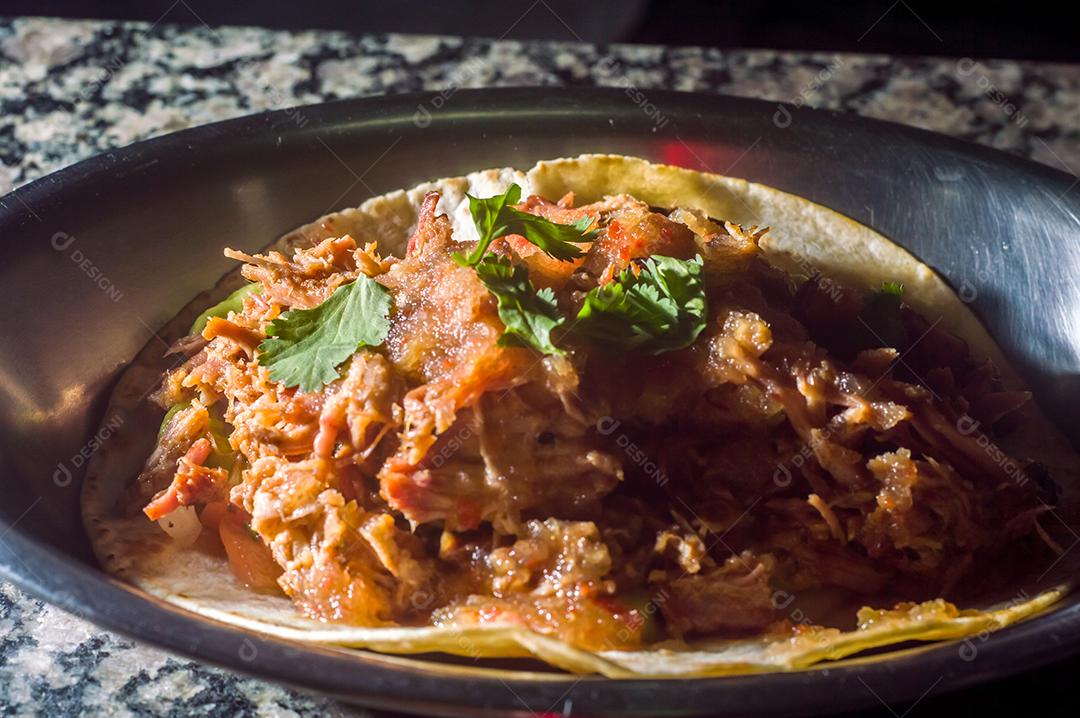 Espetinho de porco desfiado com tortilha, guacamole e fundo de maemore