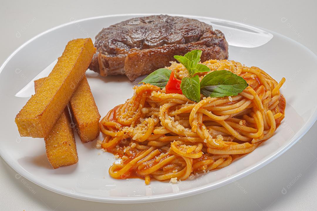 espaguete no molho sugo com parmesão servido com filé e frita