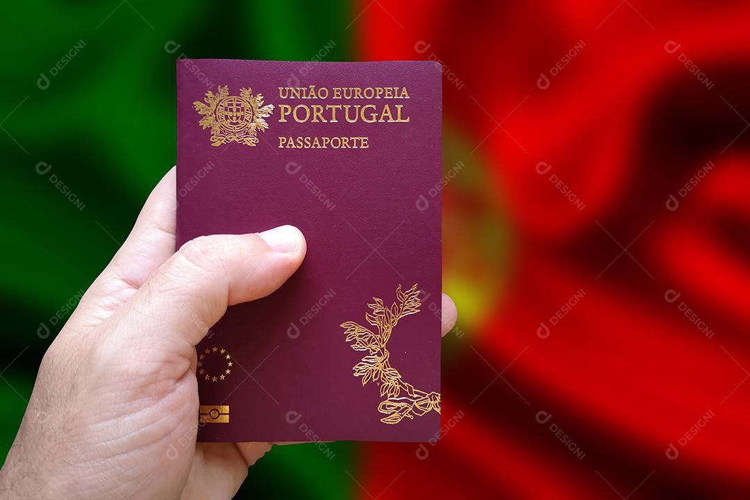 Foto Mão de Homem Segurando Passaporte Português Com Bandeira Portuguesa Desfocada