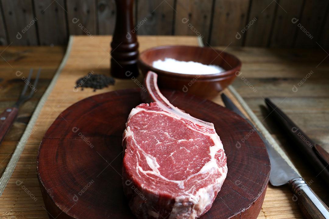 Foto Costela Prime Bife de Rib Eye Cru Com Osso para Churrasco Em Fundo de Madeira