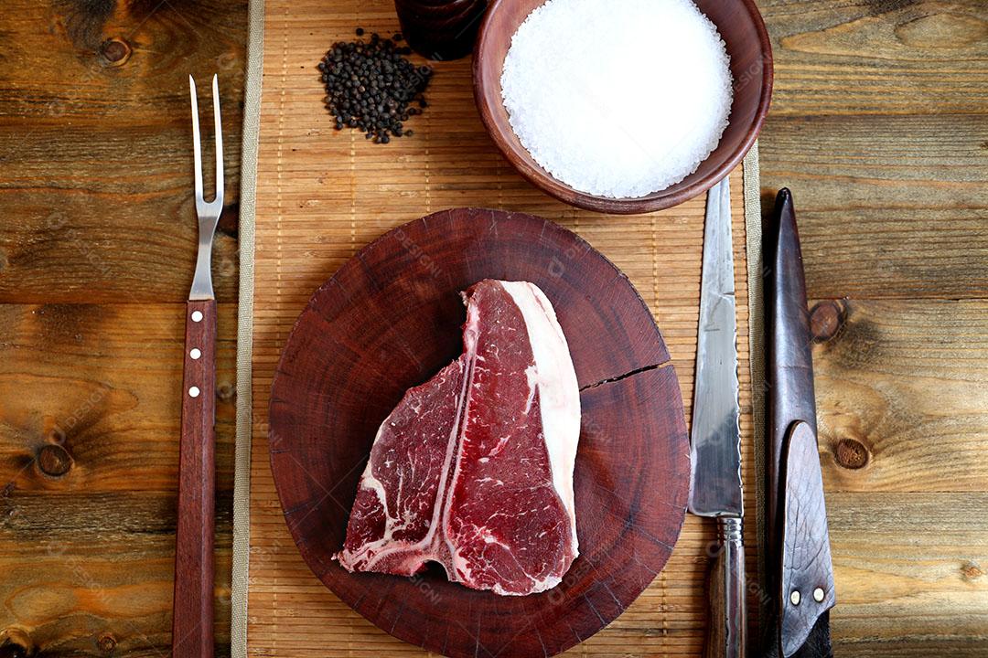 Foto Costela Prime Bife de Rib Eye Cru Com Osso para Churrasco Em Fundo de Madeira