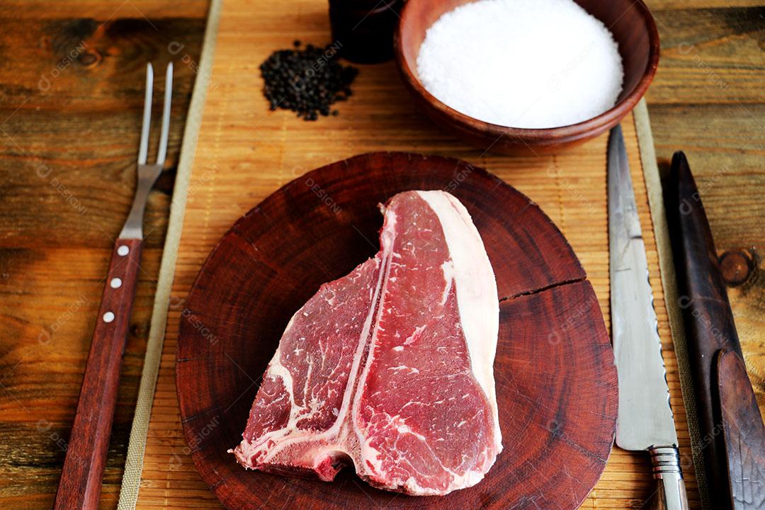Foto Costela Prime Bife de Rib Eye Cru Com Osso para Churrasco Em Fundo de Madeira