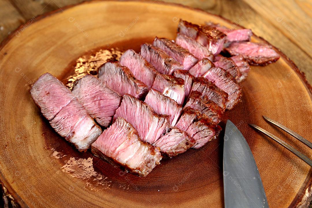 Foto Pedaços de Bife Ancho Cortados Tábua Madeira Garfo e Faca Ao Lado Vista Lateral