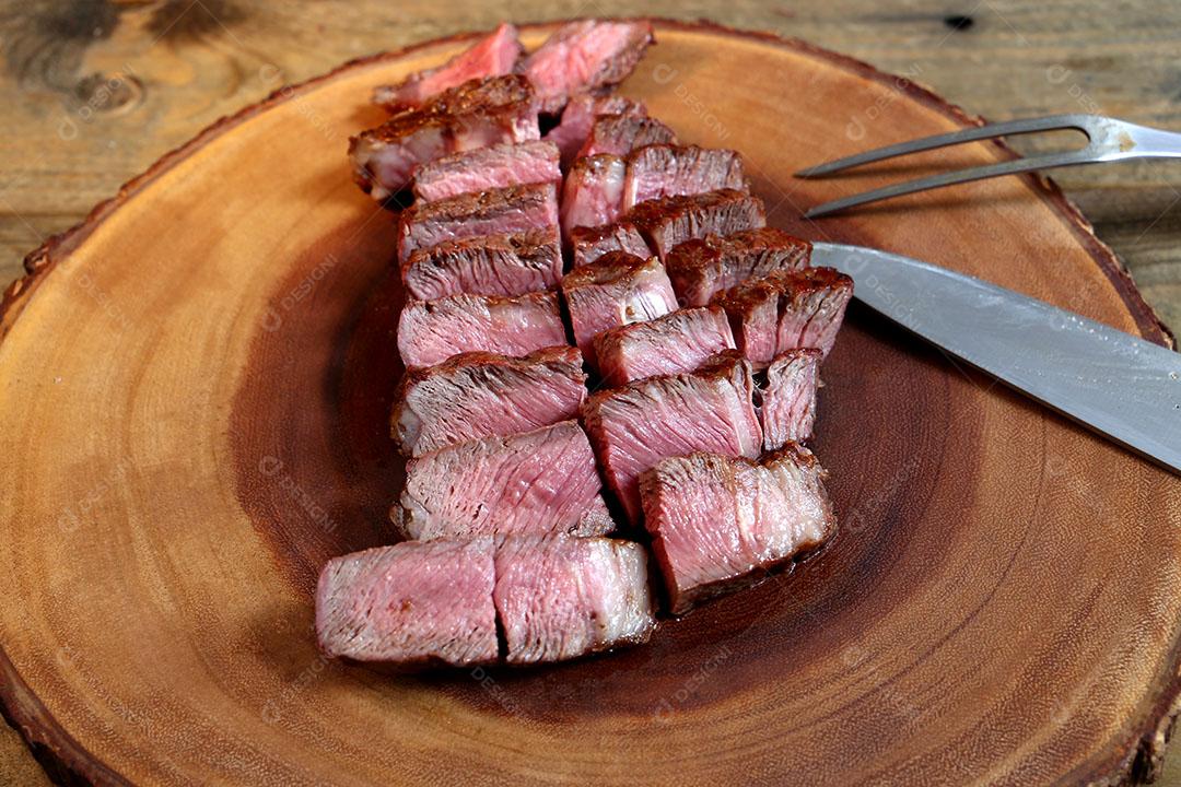 Foto Pedaços de Bife Ancho Cortados Tábua Madeira Garfo e Faca Ao Lado Vista Lateral