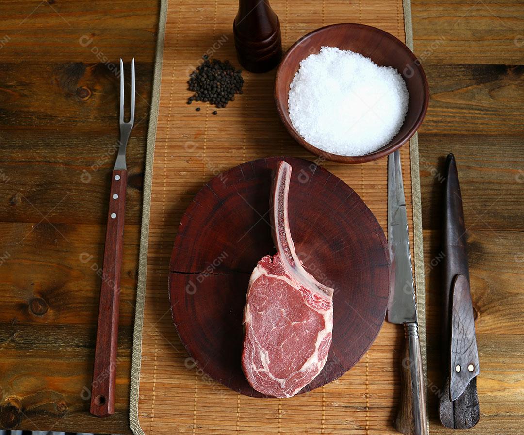 Foto Costela Prime Bife de Rib Eye Cru Com Osso para Churrasco Em Fundo de Madeira