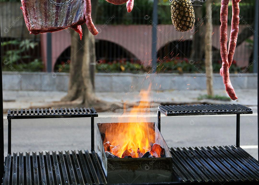 Foto Parrilla de Churrasco Argentino na Calçada Rua Brasil Com Fogo Linguiças Penduradas