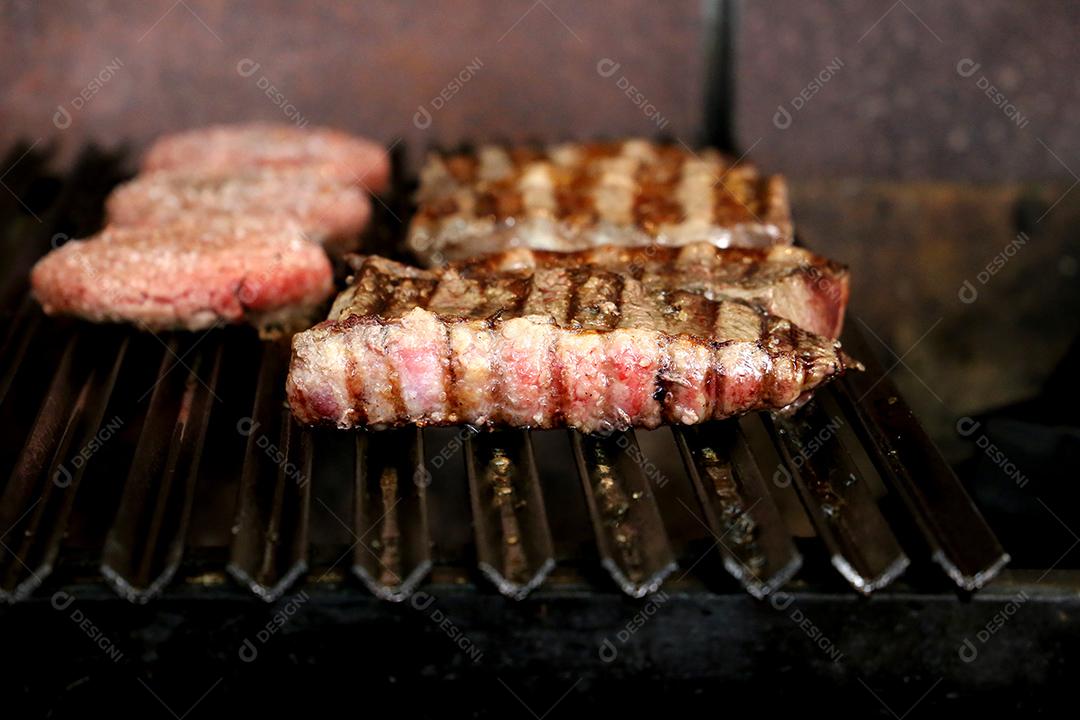 Linda e suculenta Picanha fechada com marcas de grelha em cima da grelha com carvão brilhante no fundo JPG