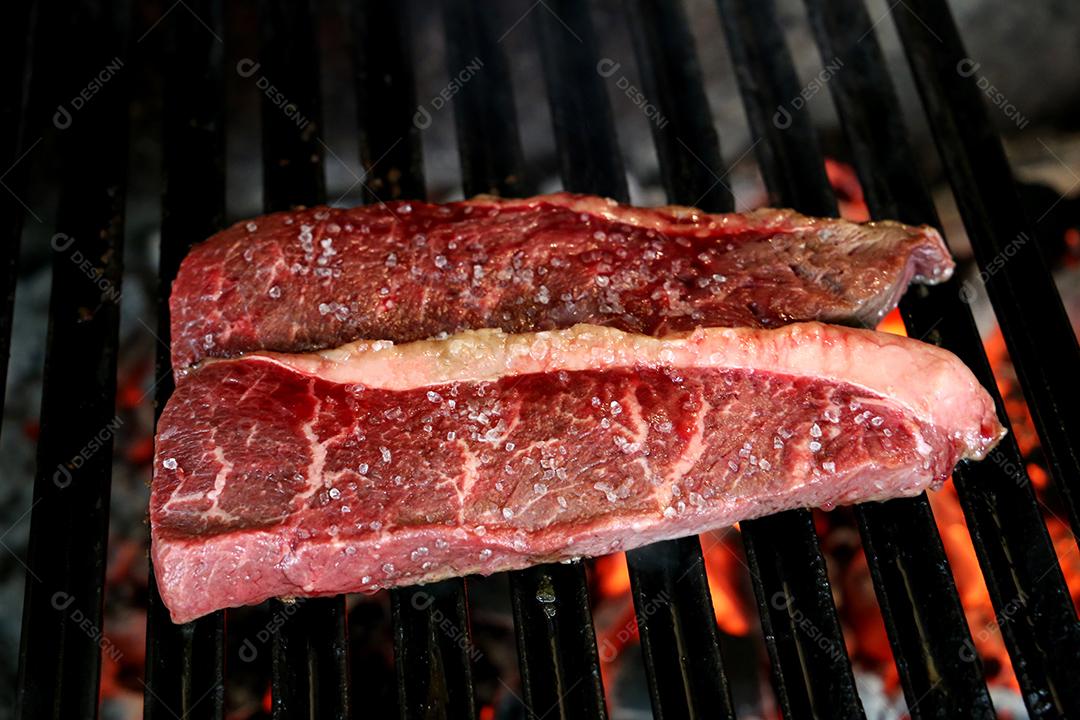 Linda e suculenta Picanha fechada com marcas de grelha em cima da grelha com carvão brilhante no fundo JPG