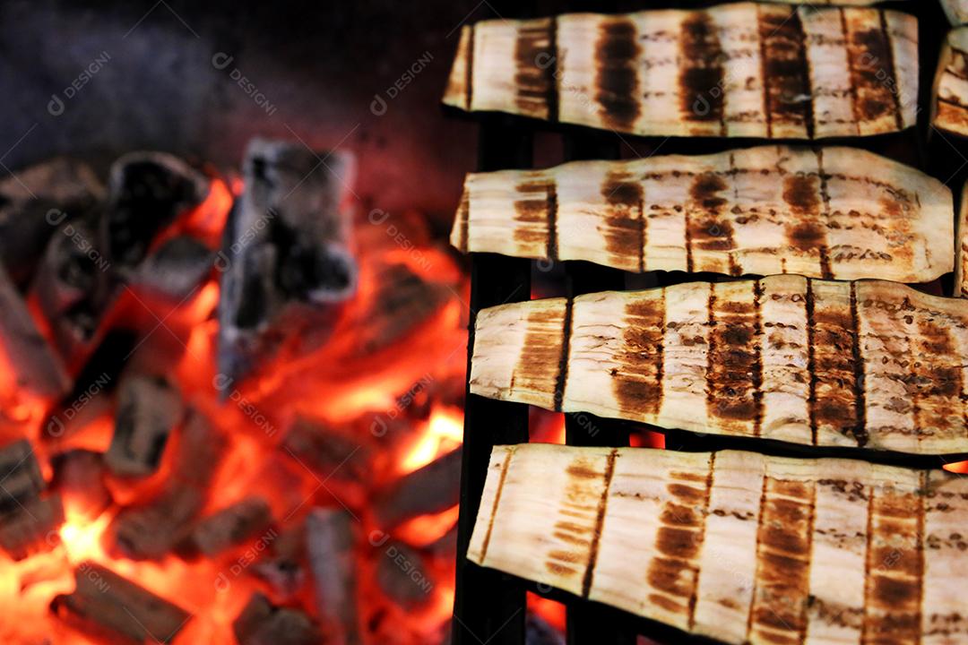 Berinjela na churrasqueira com marcas na grelha com fundo de carvão brilhante JPG