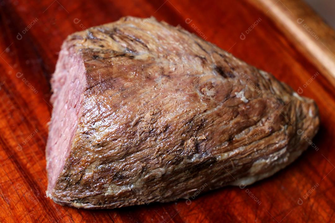 Cupim ou Cupim. Tradicional cordão brasileiro de boi Nelore cortado sob uma tábua de madeira com uma faca de churrasco JPG