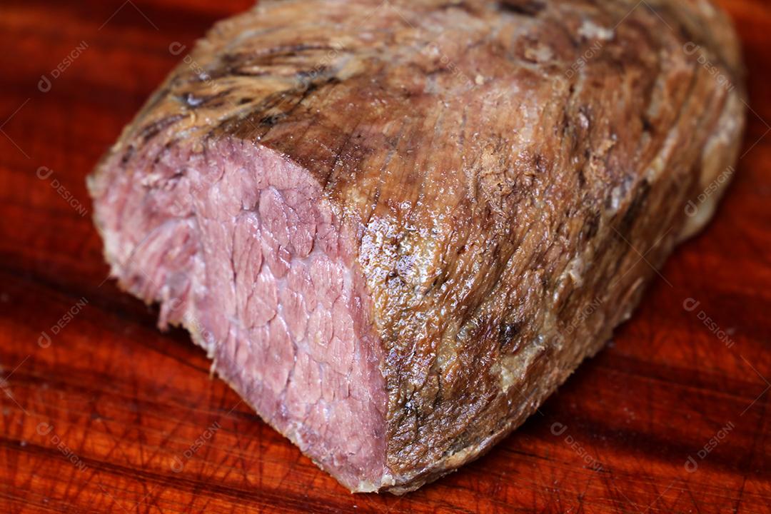 Cupim ou Cupim. Tradicional cordão brasileiro de boi Nelore cortado sob uma tábua de madeira com uma faca de churrasco JPG