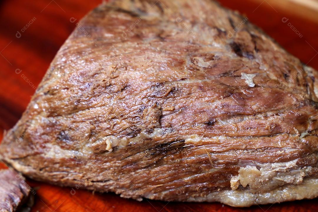 Cupim ou Cupim. Tradicional cordão brasileiro de boi Nelore cortado sob uma tábua de madeira com uma faca de churrasco JPG