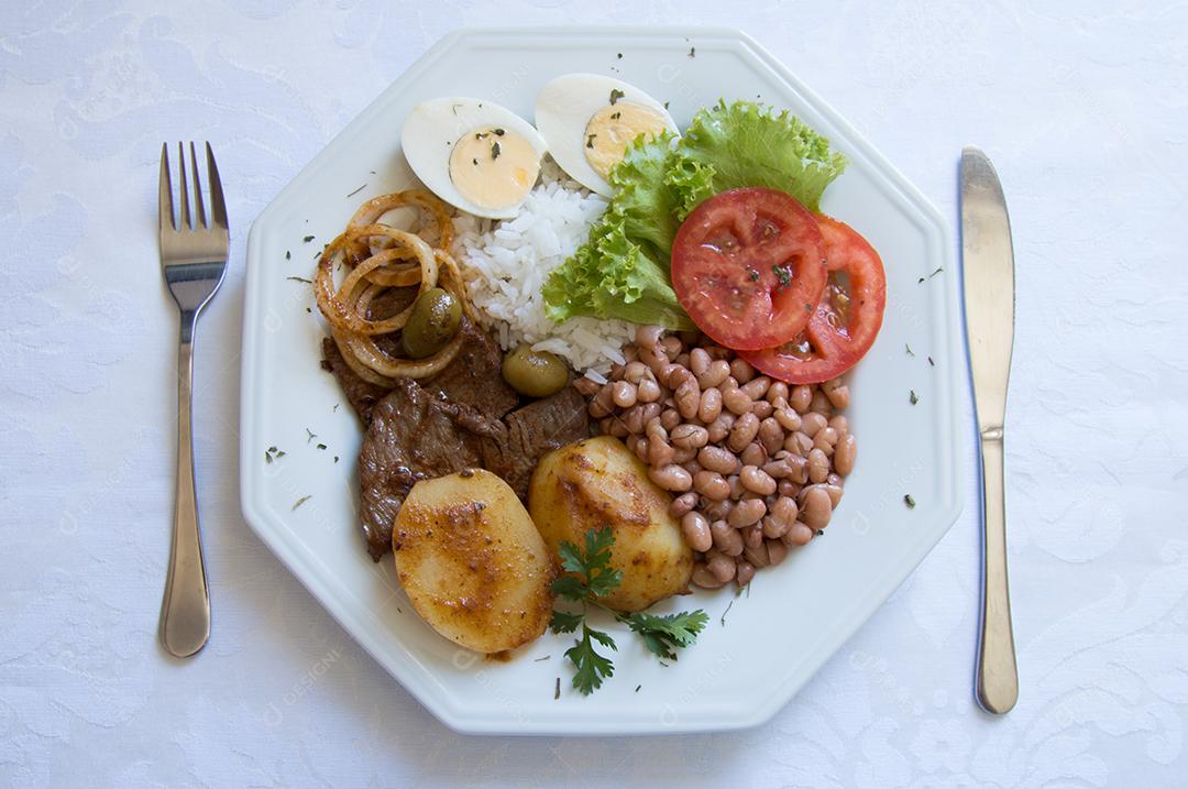 g0018 Brazilian food dish viewed from above with white background with fork and knife