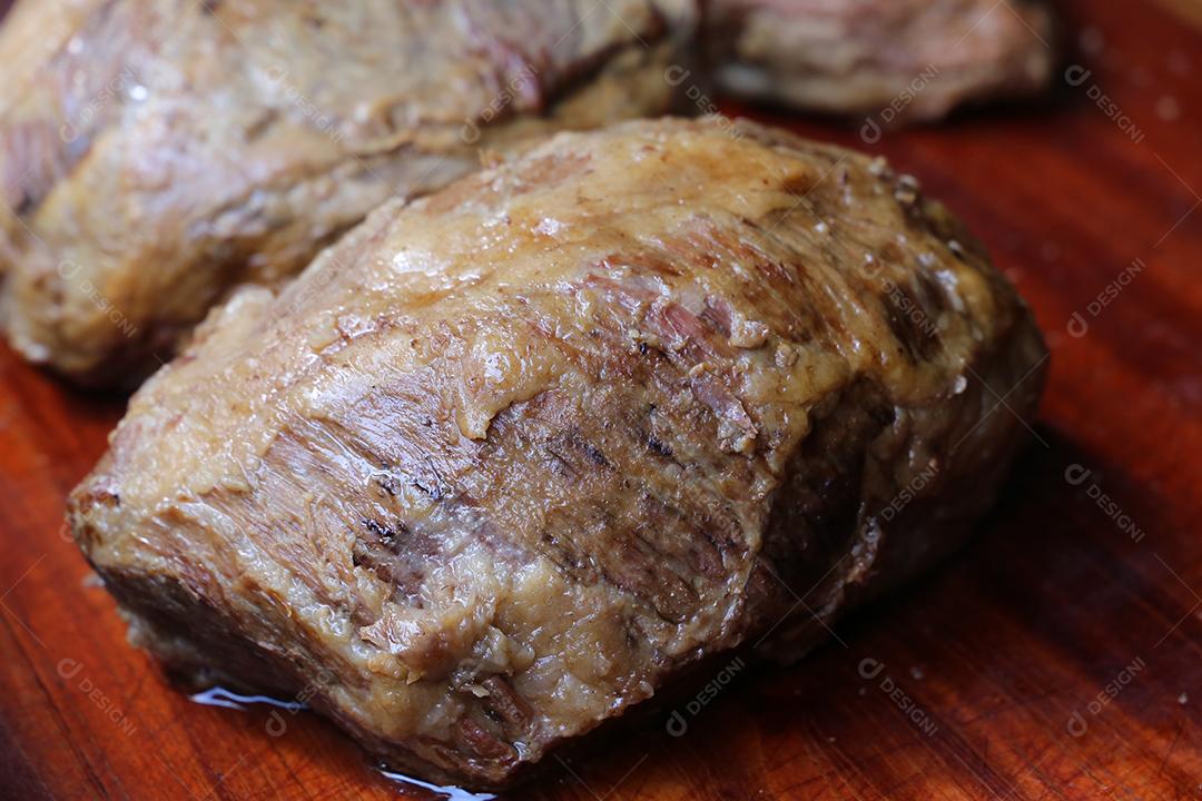 Cupim ou Cupim. Tradicional cordão brasileiro de boi Nelore cortado sob uma tábua de madeira com uma faca de churrasco JPG