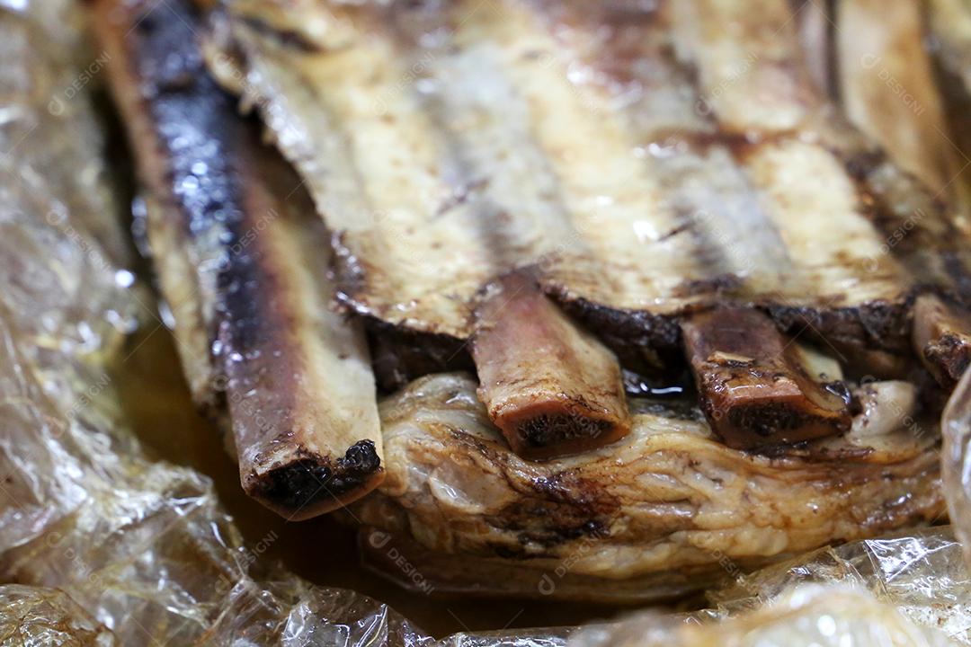 Costela, costela. Deliciosa costela assada com ossos grandes. Servido em uma tábua de madeira JPG