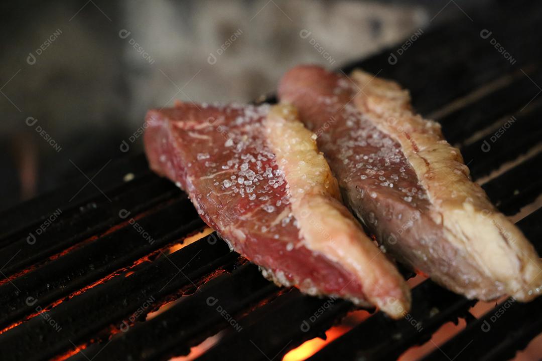 Picanha fechadas com marcas de grelha no topo da grelha com carvão brilhante no fundo JPG