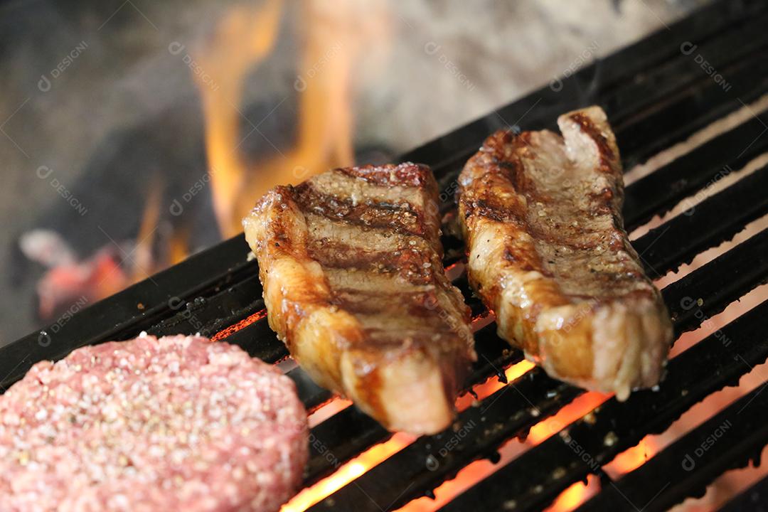 Picanha fecha com marcas de grelha no topo da grelha com carvão brilhante no fundo JPG