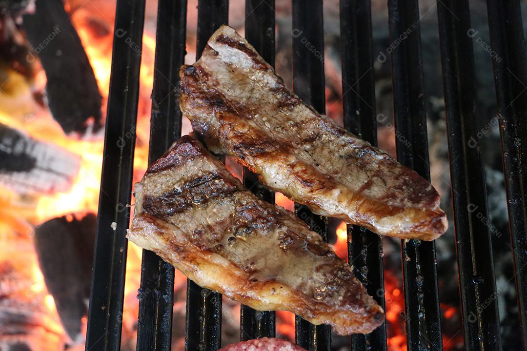 Picanha fecha com marcas de grelha no topo da grelha com carvão brilhante no fundo JPG
