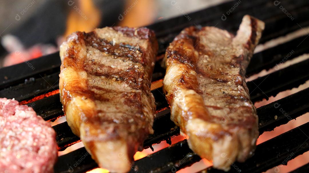 Picanha fecha com marcas de grelha no topo da grelha com carvão brilhante no fundo JPG