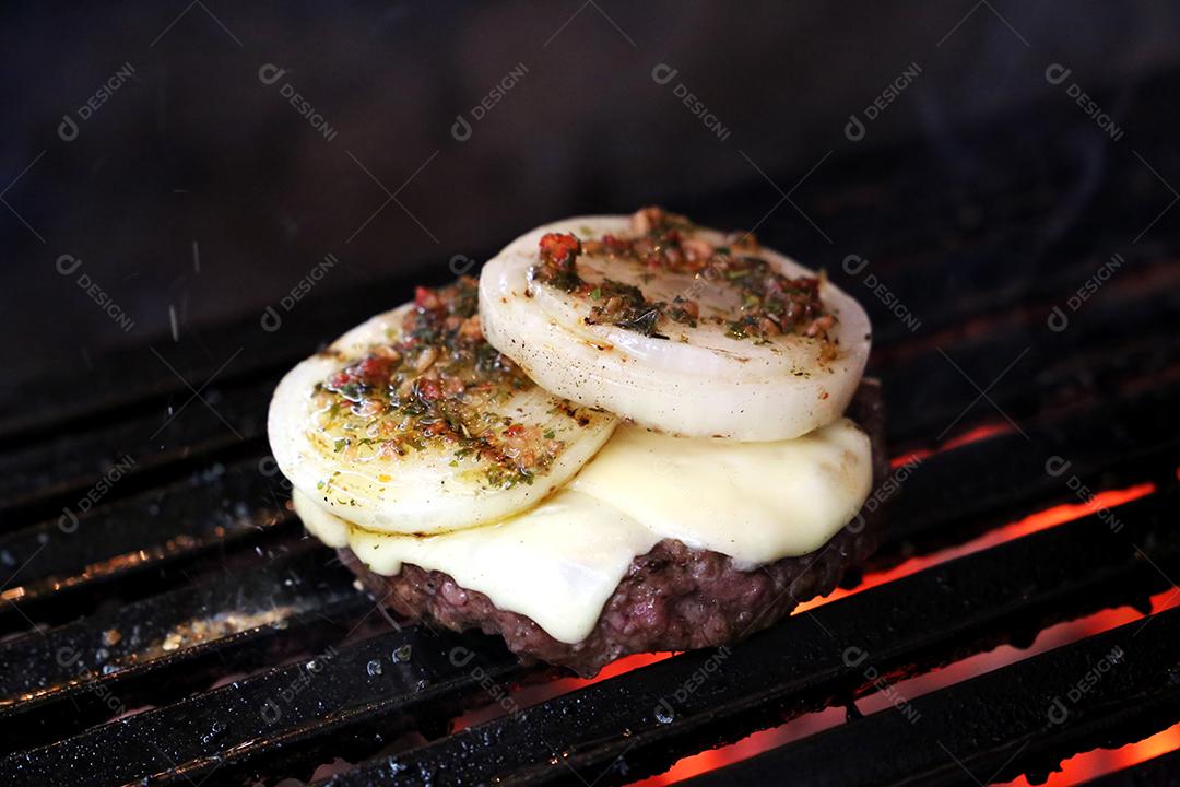 Hambúrguer com cebola. Em um churrasco JPG