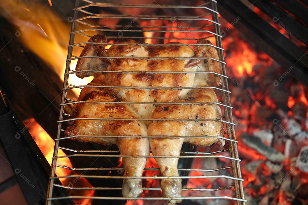 Frango inteiro grelhado em um churrasco. Comida brasileira JPG