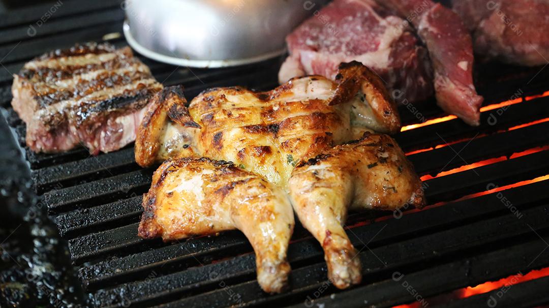 Frango inteiro grelhado em um churrasco. Comida brasileira JPG