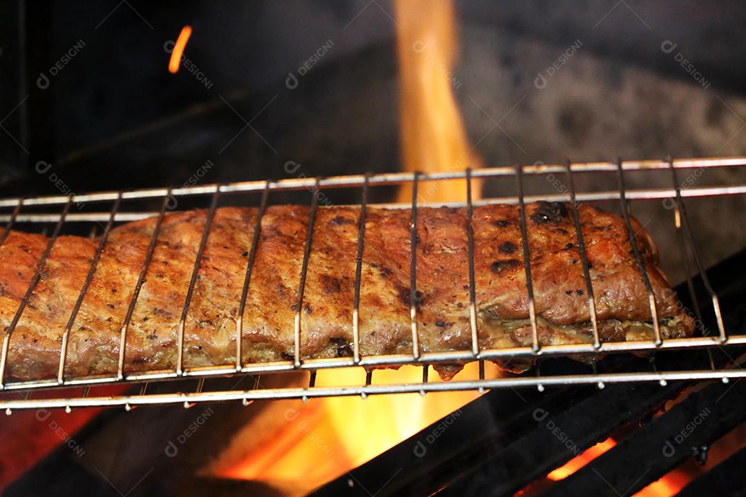 O Chouriço. Churrasco brasileiro. Bife cortado em uma tábua de madeira JPG