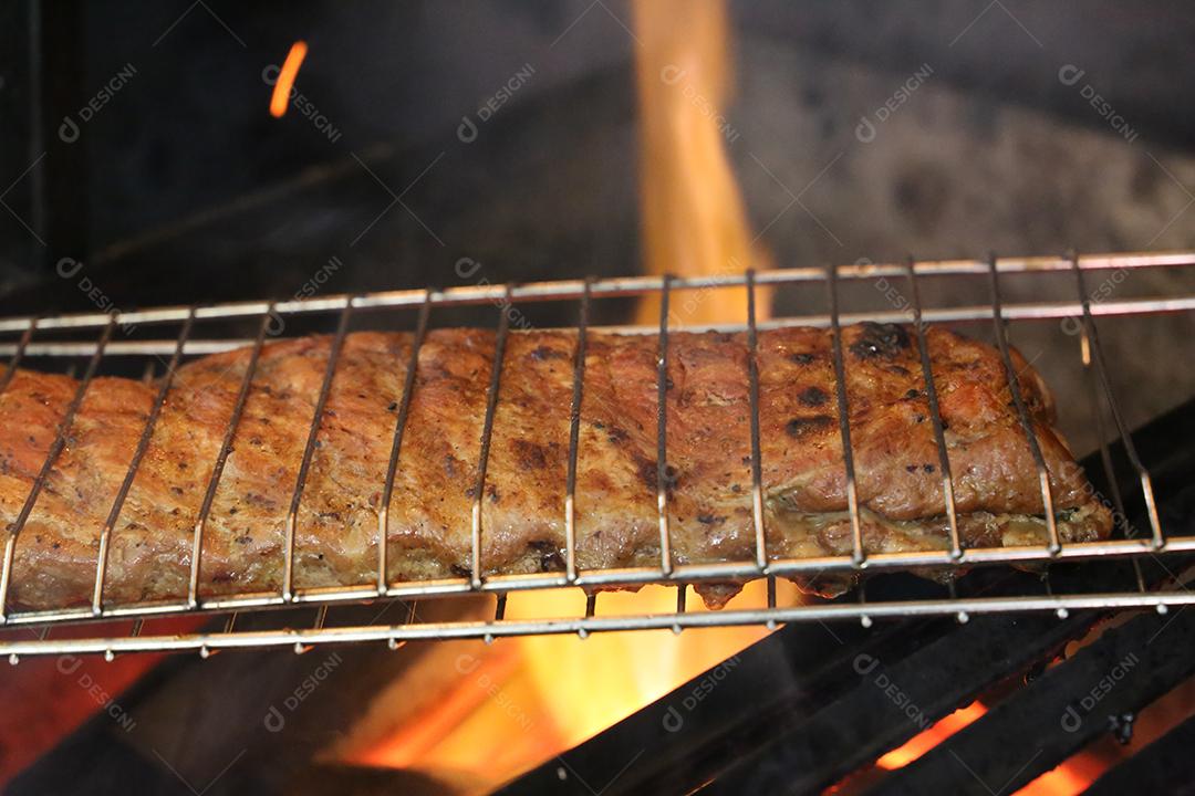 O Chouriço. Churrasco brasileiro. Bife cortado em uma tábua de madeira JPG