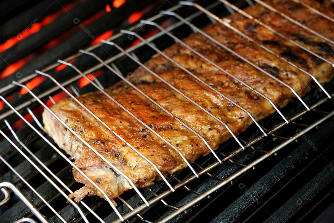 O Chouriço. Churrasco brasileiro. Bife cortado em uma tábua de madeira JPG