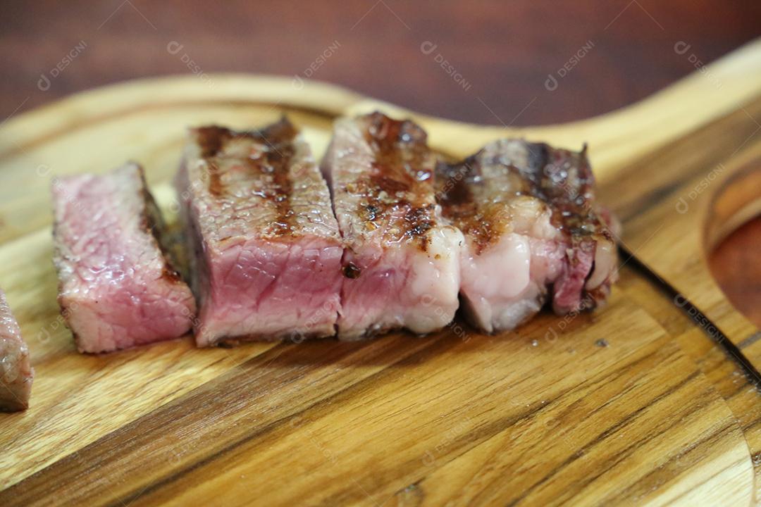 Chouriço. Churrasco brasileiro. Bife cortado em uma tábua de madeira JPG