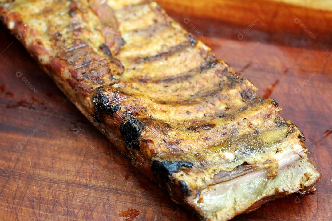 Costelas de porco no churrasco brasileiro. Com fundo de madeira JPG