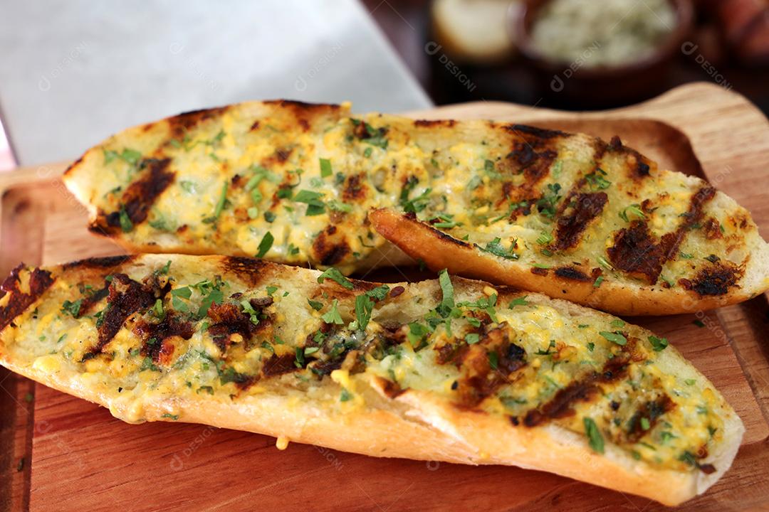 pão com alho grelhado na churrasqueira. em uma tábua de madeira JPG