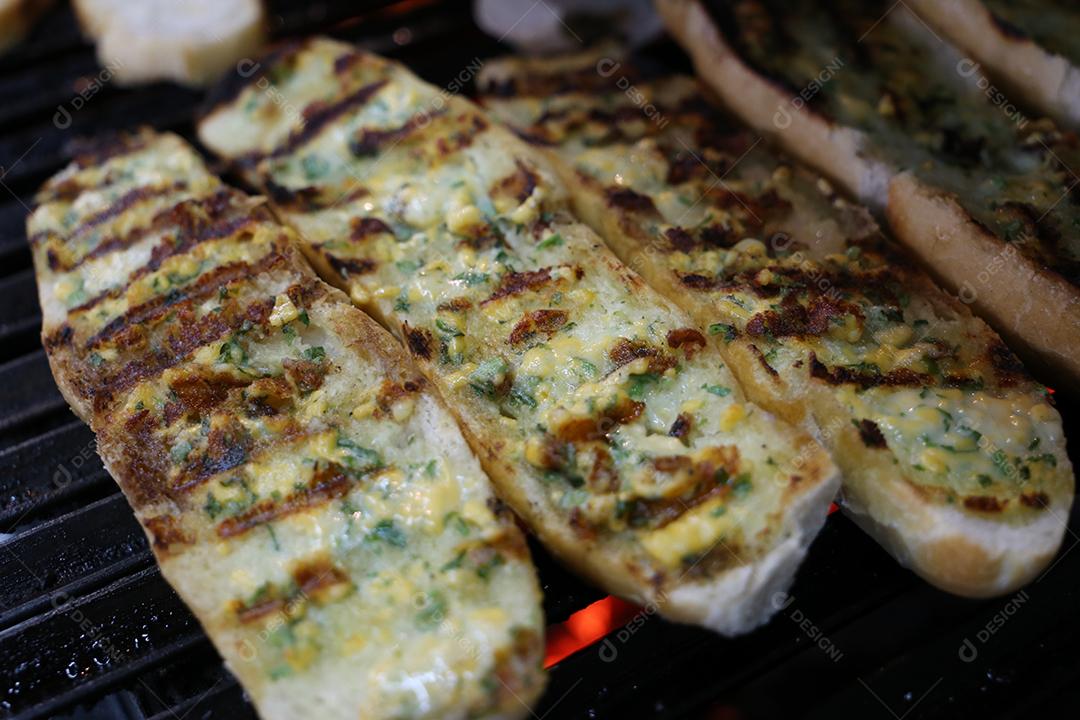pão com alho grelhado na churrasqueira. em uma tábua de madeira JPG