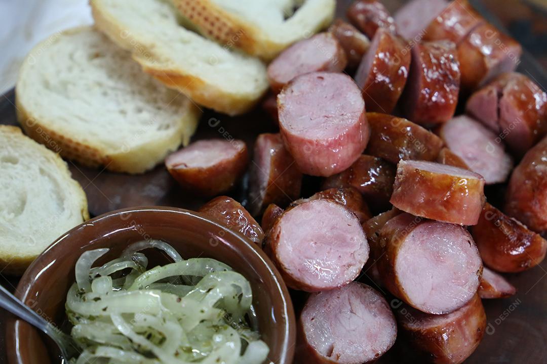 pão com salsicha e chimichurri em uma tábua de madeira. Churrasco brasileiro JPG