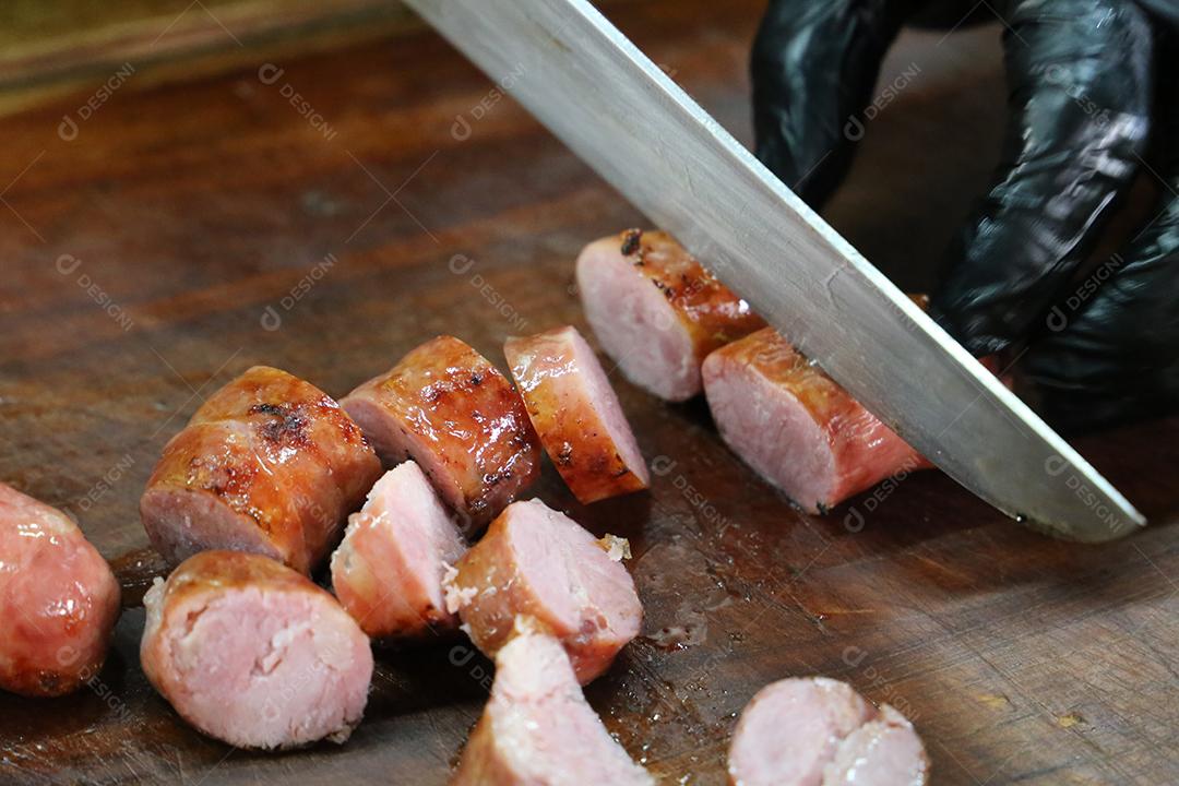 salsicha fatiada em uma tábua de madeira rústica. Churrasco brasileiro JPG