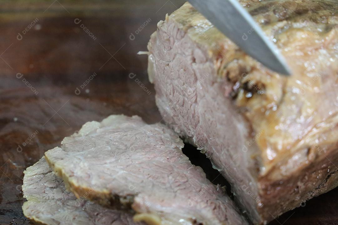 Cupim ou Cupim. Tradicional cordão brasileiro de boi Nelore cortado sob uma tábua de madeira com uma faca de churrasco JPG