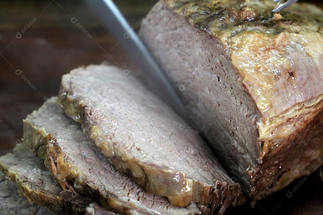 Cupim ou Cupim. Tradicional cordão brasileiro de boi Nelore cortado sob uma tábua de madeira com uma faca de churrasco JPG