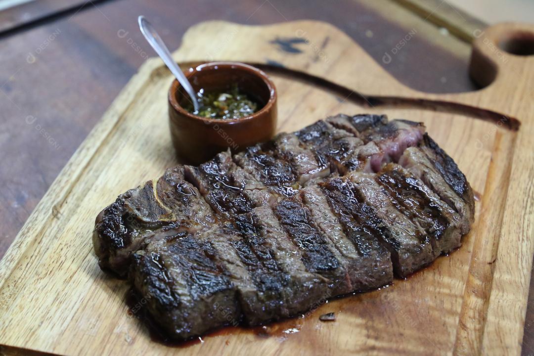 Costela curta ou Rib Premium. Bife grelhado em Parrilla argentina com marcas de grelha em uma tábua de madeira ao fundo. Comida brasileira JPG