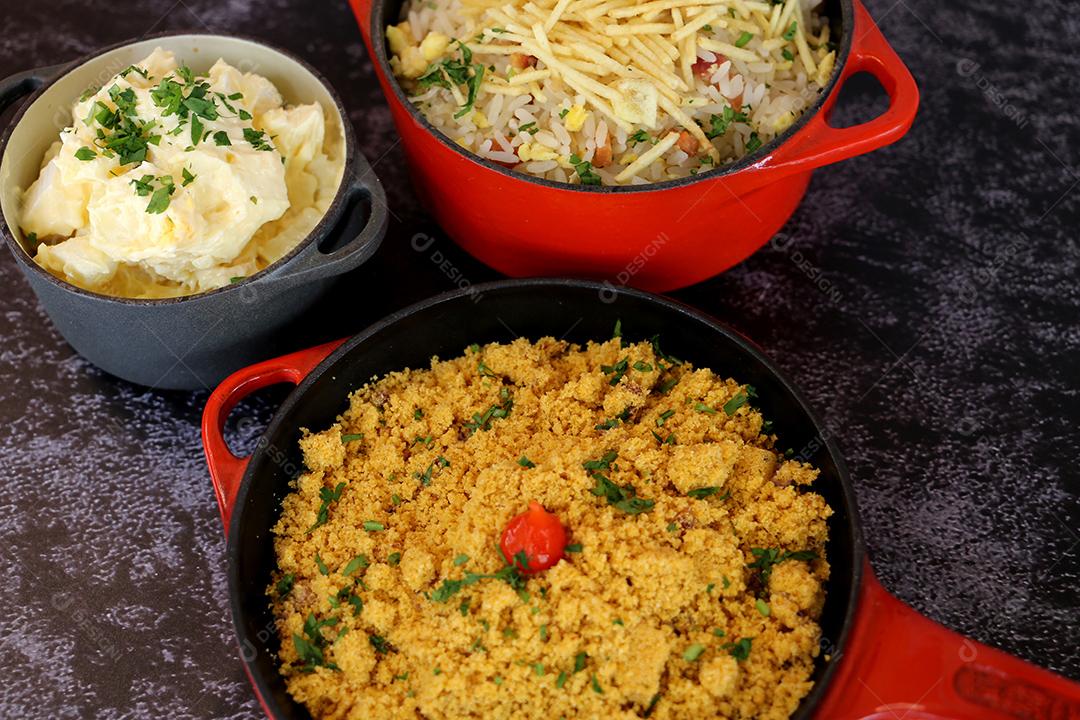 pote de ferro vermelho com Farofa. Comida tradicional brasileira. Em um fundo escuro JPG