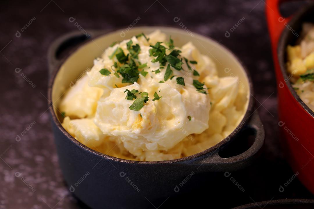 salada de maionese com batatas e salsa. Em uma pequena panela preta. Comida brasileira JPG
