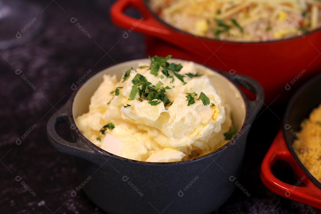 salada de maionese com batatas e salsa. Em uma pequena panela preta. Comida brasileira JPG