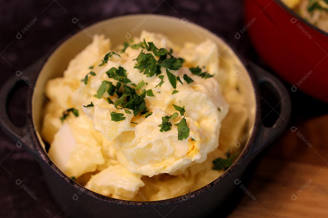 salada de maionese com batatas e salsa. Em uma pequena panela preta. Comida brasileira JPG