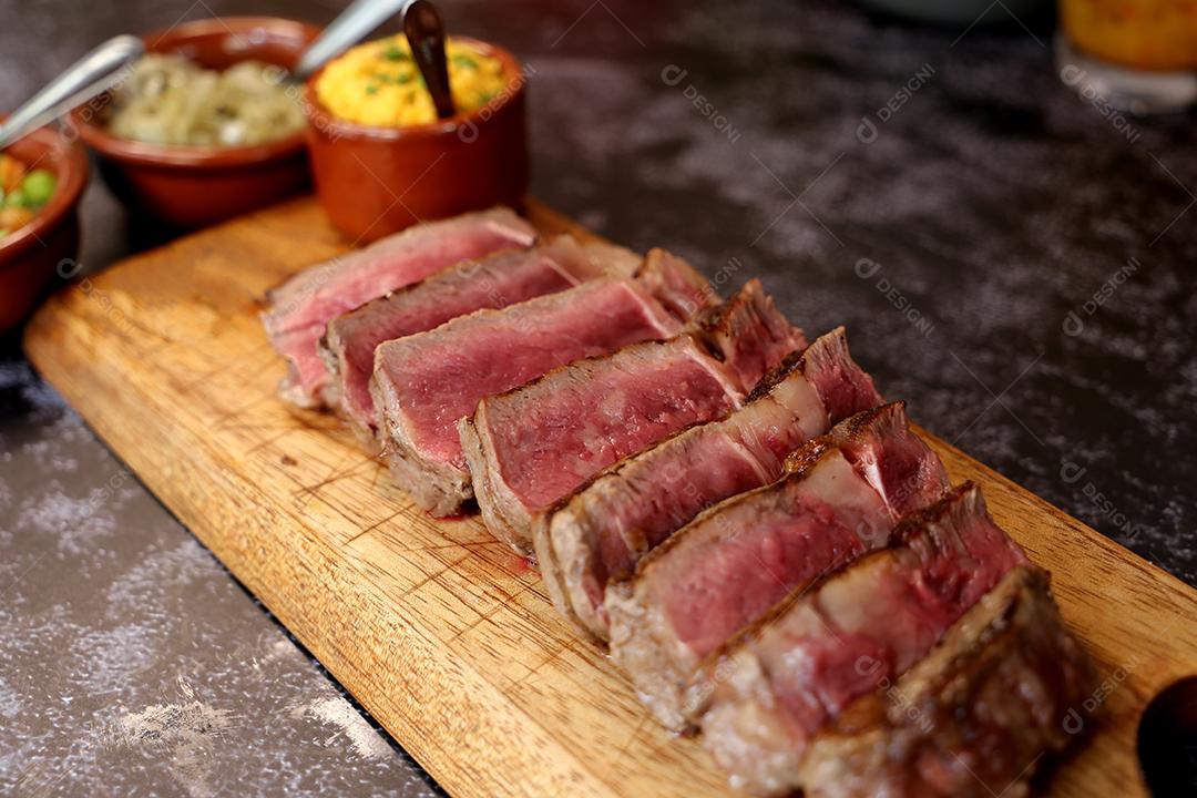 Costela curta ou Rib Premium. Bife grelhado em Parrilla argentina com marcas de grelha em uma tábua de madeira ao fundo. Comida brasileira JPG